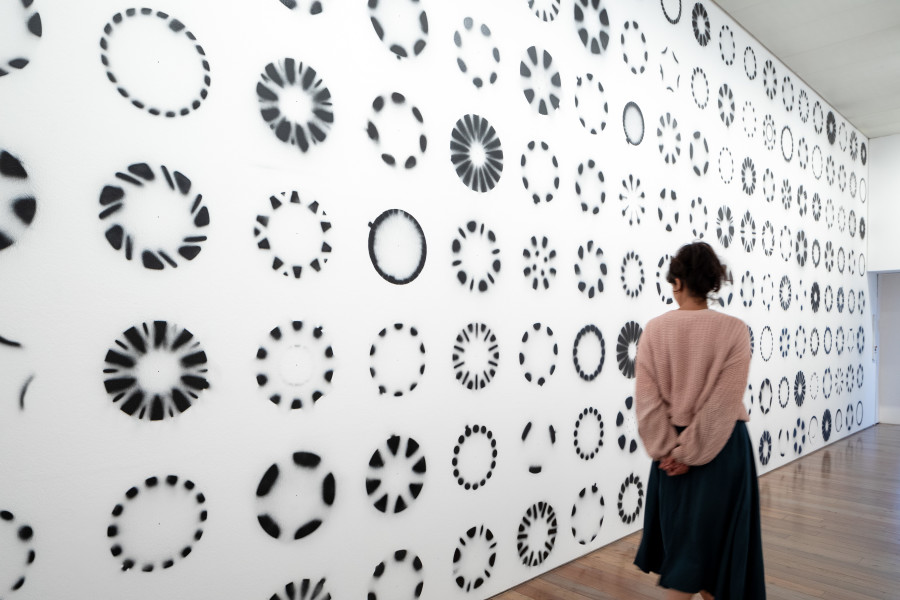 Delphine Reist, Enjoliveurs [hub caps], 2014, Spray paint, mural, Installation view Delphine Reist. ÔL {oil, olio, huile] at Museum Tinguely, Base!, 2023, Courtesy Delphine Reist, Galerie Lange+ Pult, Galerie Laurent Godin, © Delphine Reist, 7	Photo: 2023 Museum Tinguely, Base!; Bettina Matthiessen,