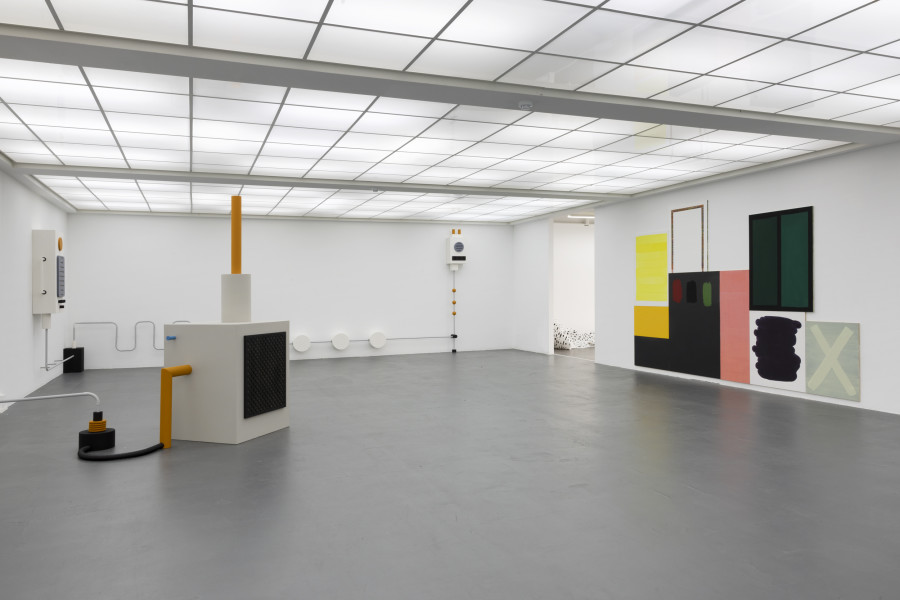 Laura Mietrup & Robin Michel, Basement Hum, 2022, Karton, Holz, Dispersion, PVC Röhren, Arduino, Ventilatoren, Hubmagnete, Flaschen, Zither, Melodica, Masse variabel. Matthias Huber, GELB, 2022, Acryl auf Holz, 110 × 74cm; OHNE TITEL, 2022, Wandtafelfarbe und Acryl auf Holz, 92 × 76cm; OHNE TITEL, 2023, Acryl auf Holz, 95 × 73cm; OHNE TITEL, 2023, Wandtafelfarbe und Acryl auf Holz, 140 × 140 cm (2-teilig); OHNE TITEL, 2023, Aktivkohle und Acryl auf Holz, 117 × 85cm; OHNE TITEL, 2012, Acryl auf Holz, 90 × 75cm; OHNE TITEL, 2014, Acryl auf Holz, 80 × 60cm. Installation view Kunsthaus Baselland. Photo: Gina Folly