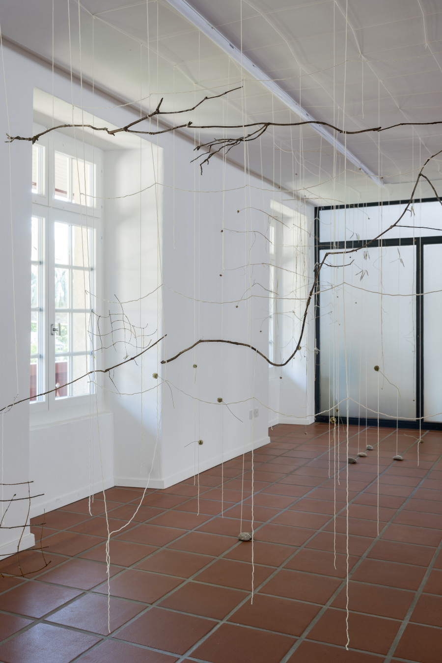 Julia Steiner, «Partitur der Natur», 2023. Ortsspezifische Installation. Baumwollgarn, Pflanzenteile, Flusssteine. Foto: Ullmann.Photography