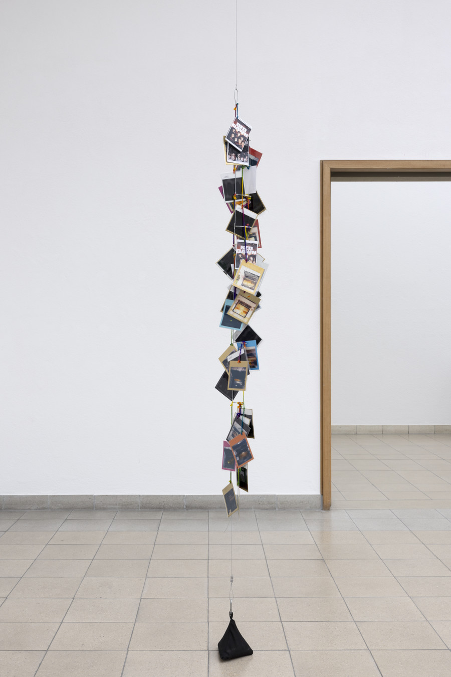 Rochelle Feinstein, The Today Show, installation view, Kunsthaus Glarus, 2025. Photo: Gina Folly. Courtesy the artist and Galerie Francesca Pia, Zurich. Golden Moments Silver Linings 1, 2021–2024, Hand-dyed Yarn, gouache, watercolour on laminated Polaroid film, alligator clips on wire, Height variable, approx. 70 x 5 in